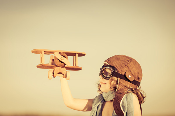 Happy kid playing with toy airplane on Photodune