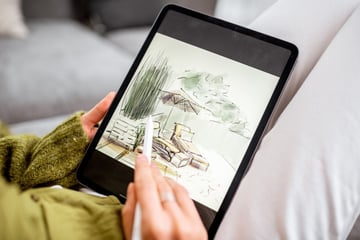 Woman drawing landscape design on a digital tablet
