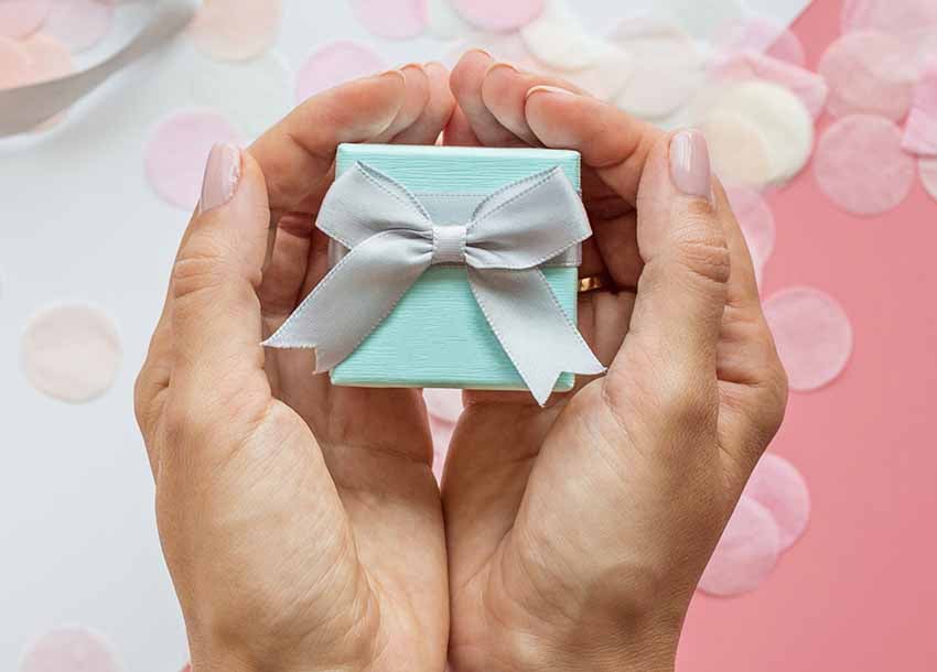 Female Hands Holding Gift box with Tiffany Jewelry 