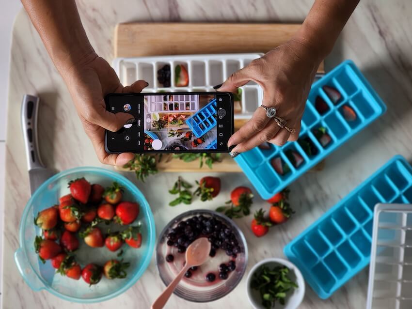 person taking a phone photo of food for social media