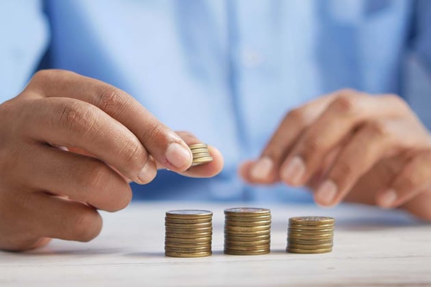 man stacking coins to work out budget