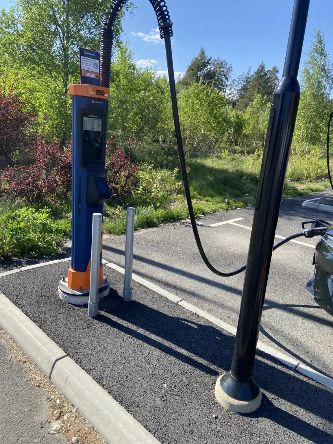 Electric car charger. Screen quite high and it sits on a raised ground with poles in the way of the charging post.