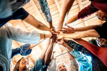 Group of people in a circle with their hands together