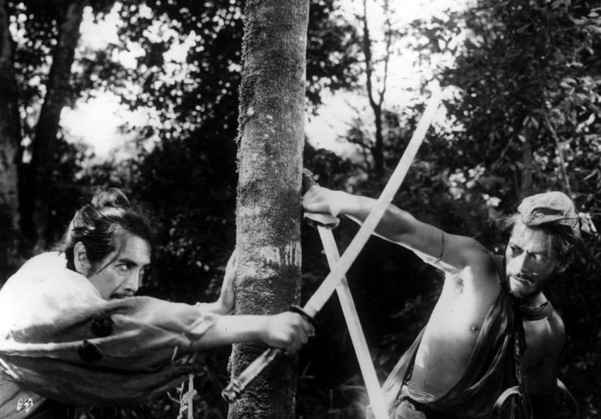 two men fight with swords around a tree